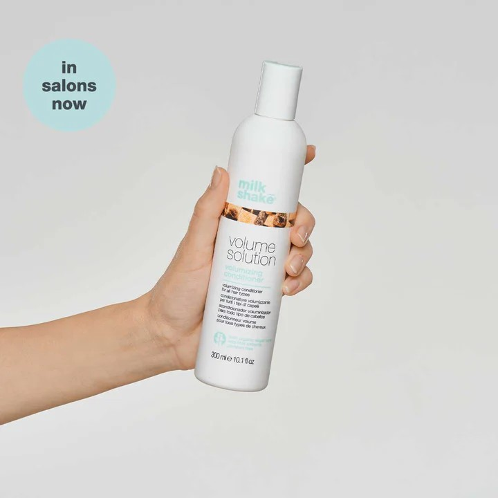 Milk_Shake Volumizing Conditioner model holding bottle